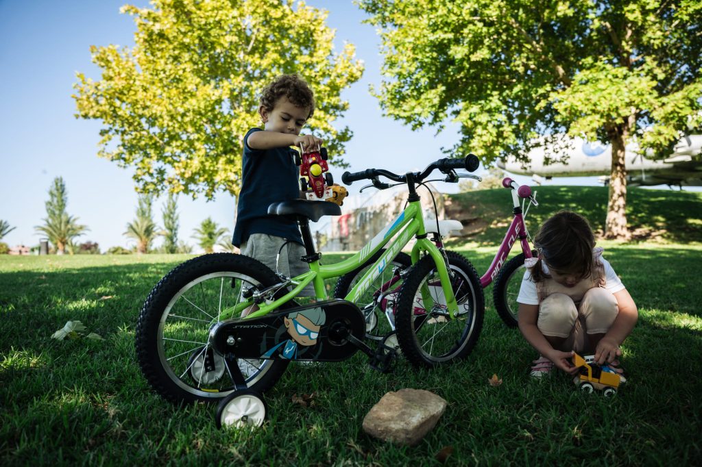 Niños jugando con bicicleta con ruedines